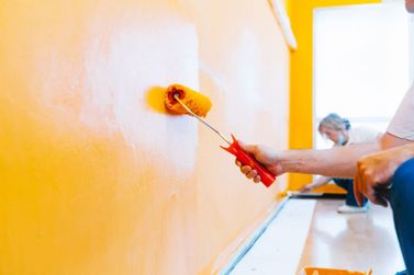 operarios pintando una pared de amarillo