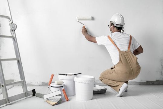 operario pintando una pared de blanco